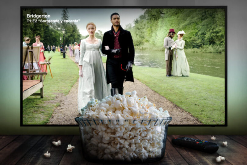 Season 1 Episode 2 of Bridgerton playing on a TV screen with a bowl of popcorn in front