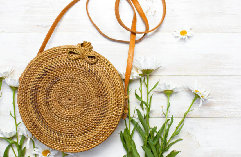 Rattan bag surrounded by chamomile flowers