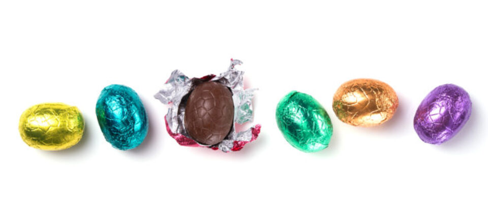 Six brightly colored foil wrapped chocolate eggs