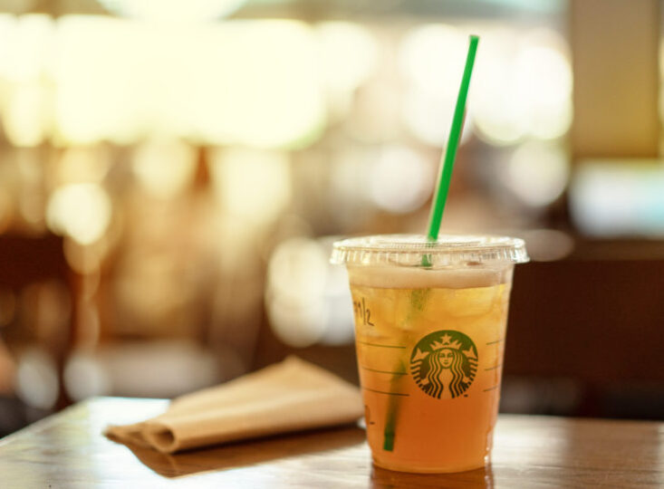 Iced Peach Green Tea Lemonade sitting on a table in Starbucks