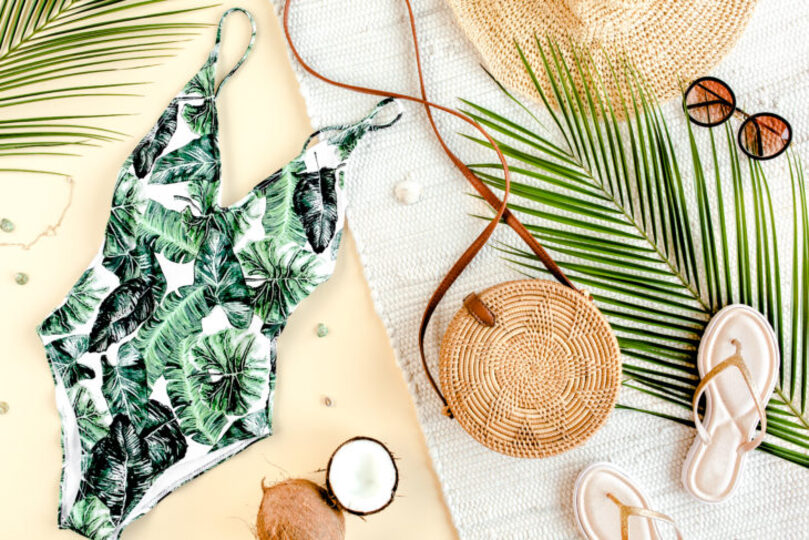 Leafy swim suit pattern with a bag, hat, and sunglasses. 