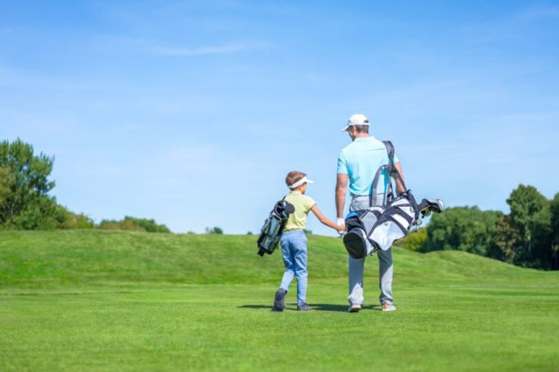 Dad and son walking on a golf course