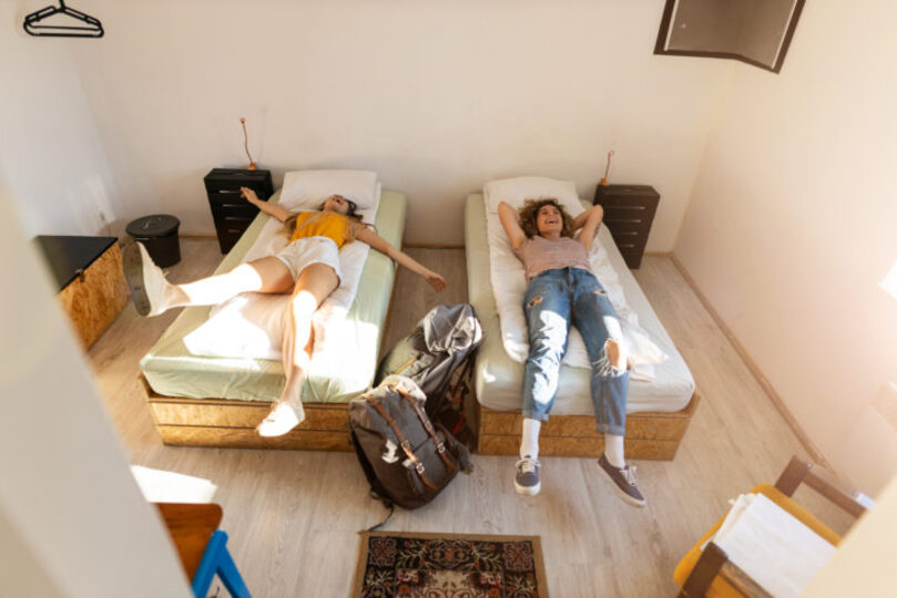 two girls moving into their dorm room, view from above them looking down