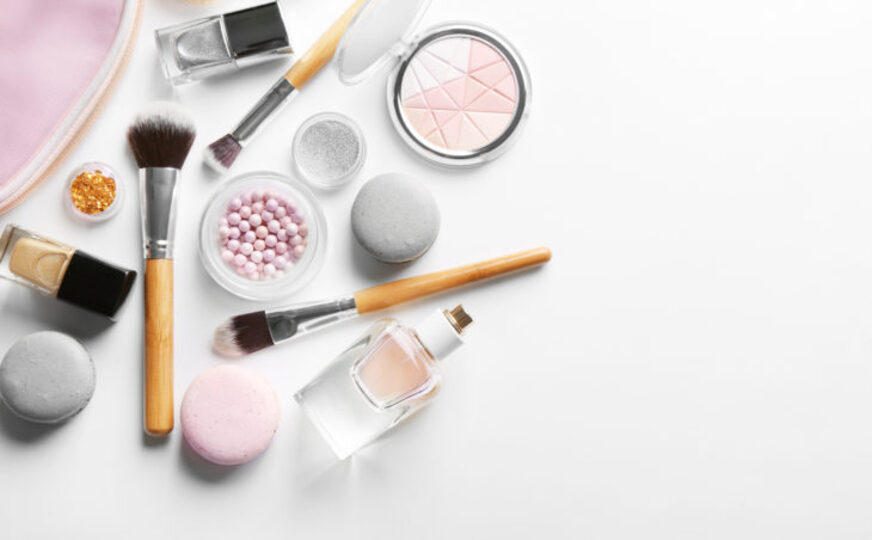 an array of makeup products on a white table looking down on them
