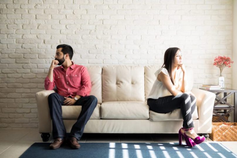 Couple being distant from each other on couch