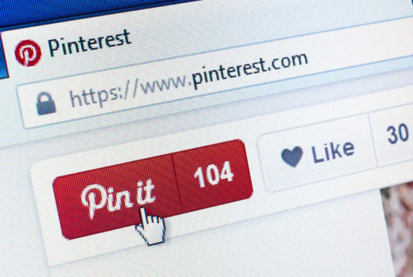 Someone pressing the “pin” button on Pinterest