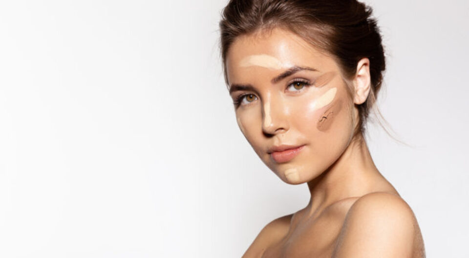 young woman with different colors of foundation on, brown hair, topless