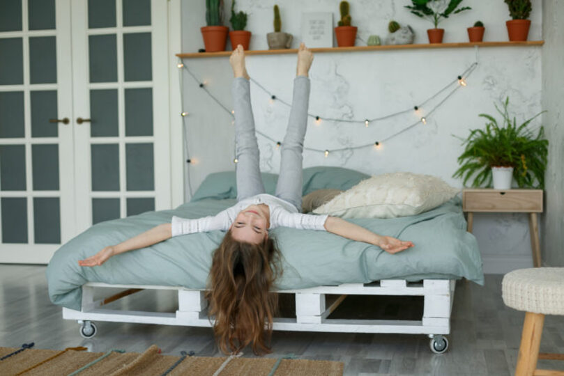 girl laying with her feet up on her bed, really cute trendy bedroom