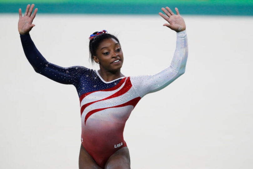 Simone Biles with her arms up