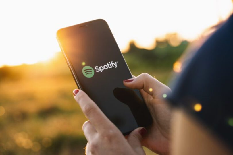 Someone using a phone with the Spotify logo on it