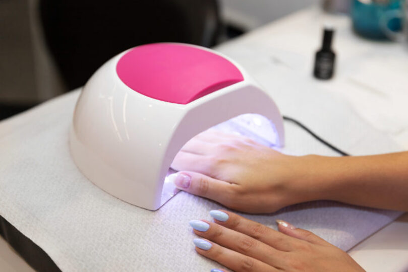 gel nail polish, women with hand in uv light manicure machine